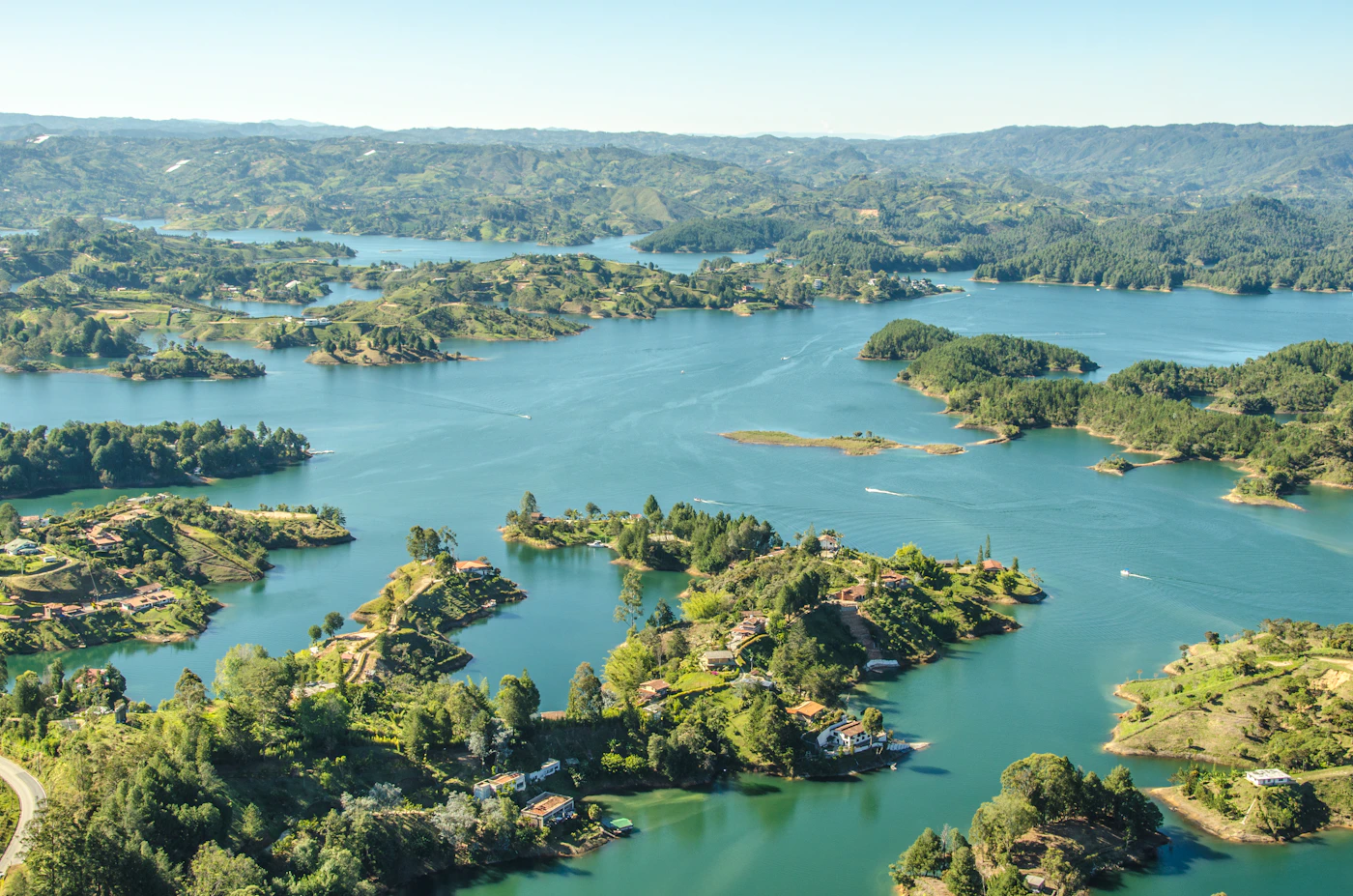 Medellín's Guatapé reservoir in golden hour light with the reflections in the water and the tropical vegetation