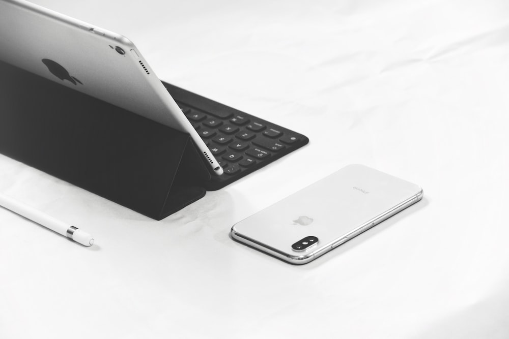 silver iPhone X beside MacBook Pro