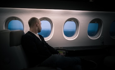man seating near window in a plane