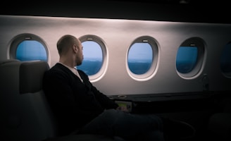 man seating near window in a plane