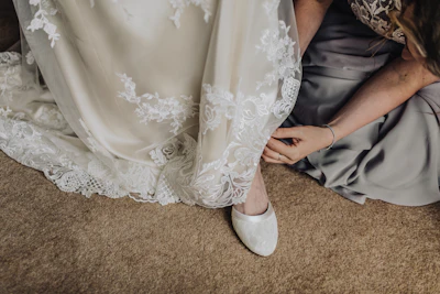 woman fixing shoes of another woman