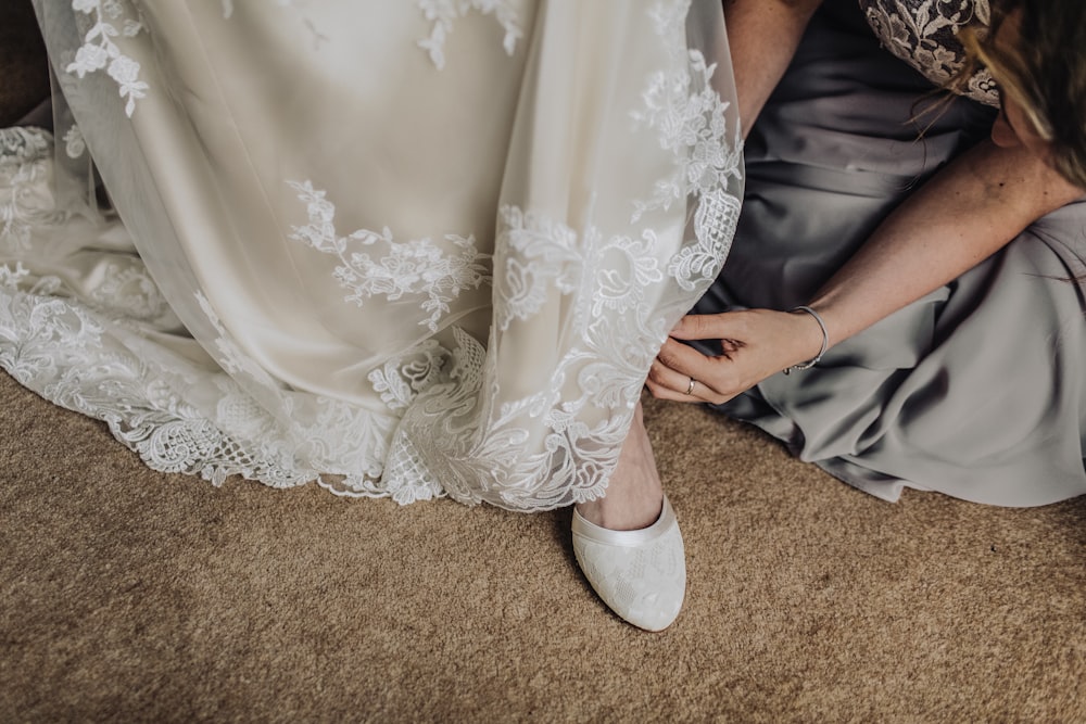 woman fixing shoes of another woman