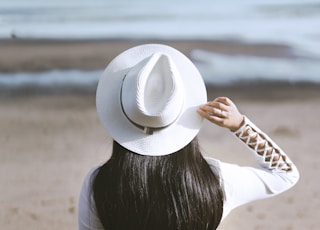 woman sits on rock watching ocean