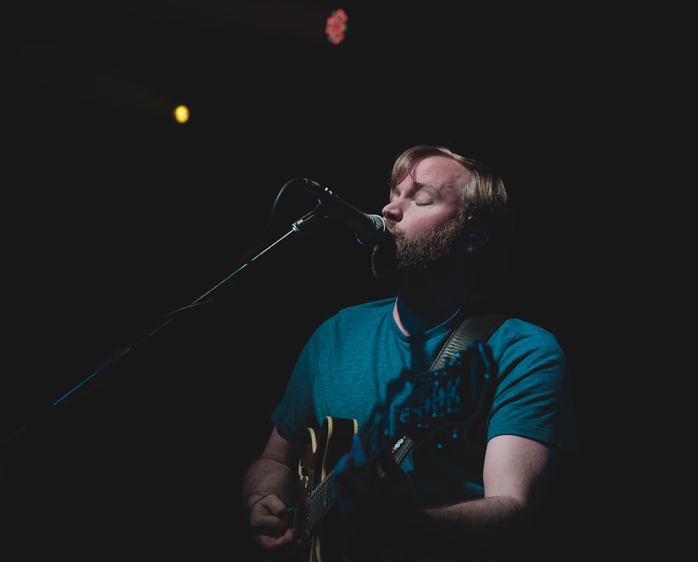 man singing while playing guitar