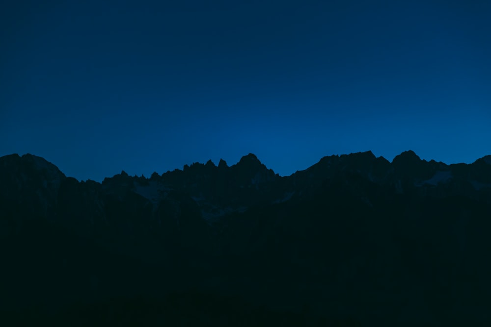 silhouette of mountains at nighttime