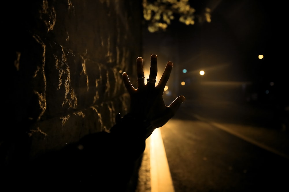 person signing stop near road during night time