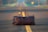 A brown leather duffel bag is placed on the yellow center line of an empty, blurred road stretching into the distance. The background is out of focus, suggesting a rural or remote setting.