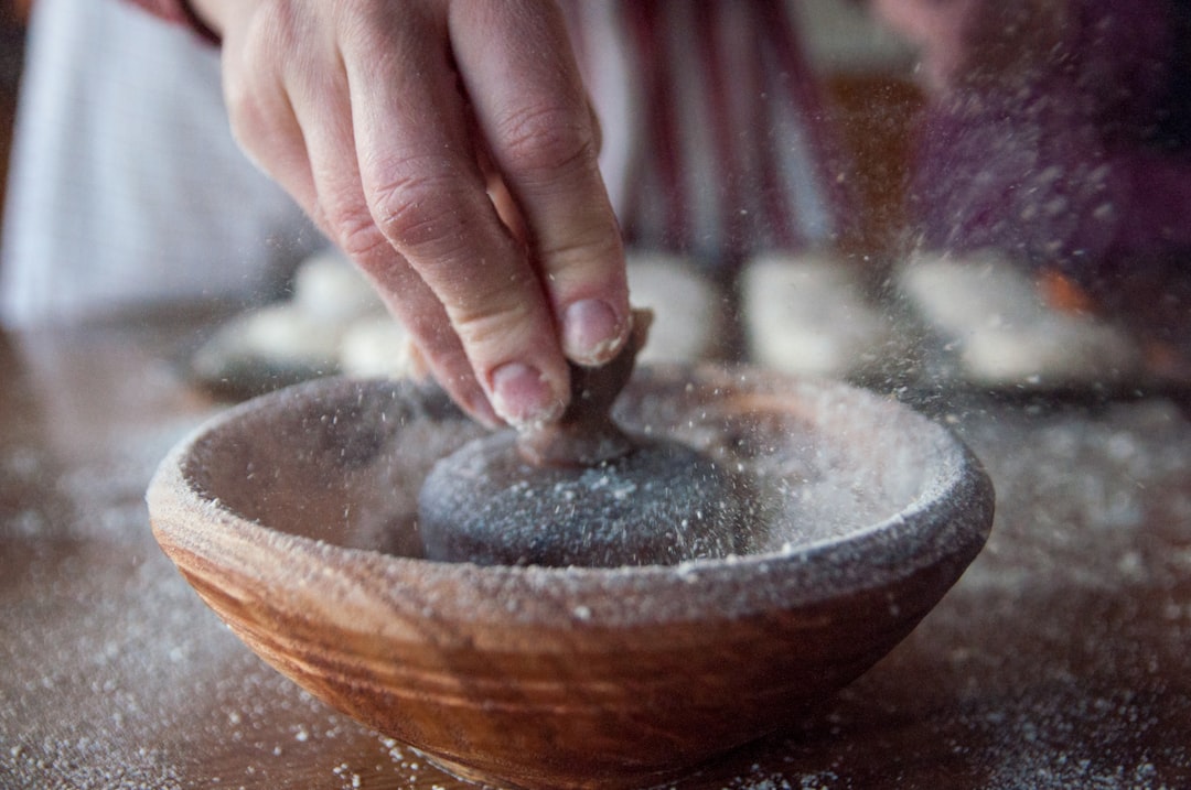 person holding brown wooden bowl