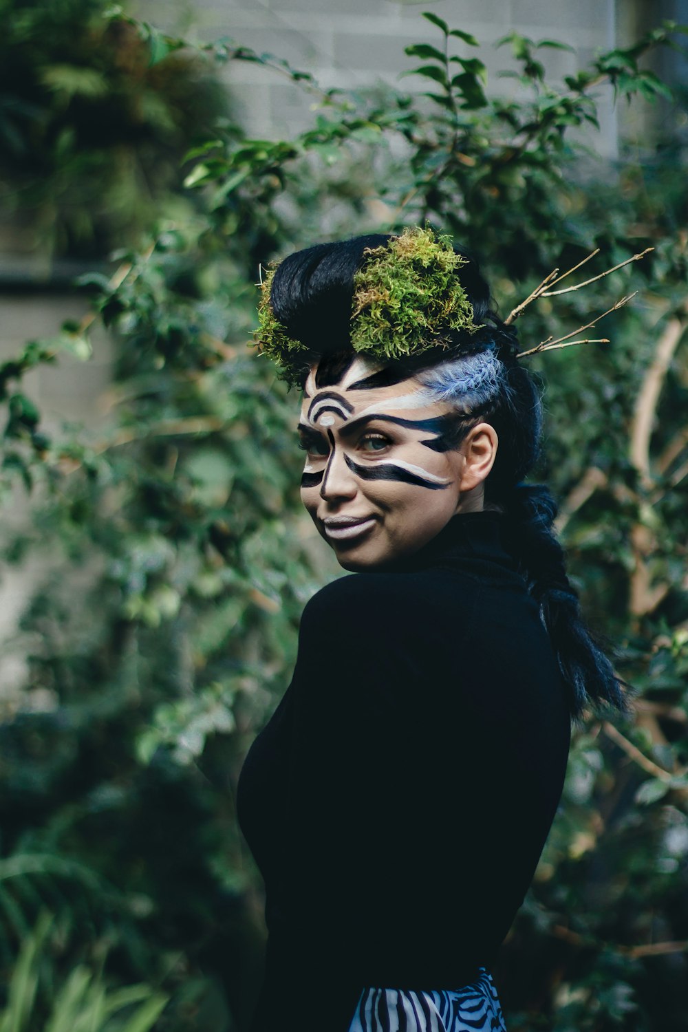 woman wearing black turtleneck top with face paint and headdress