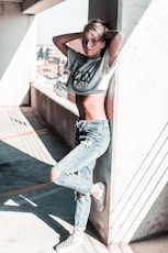 woman wearing gray crop top leaning her back on wall