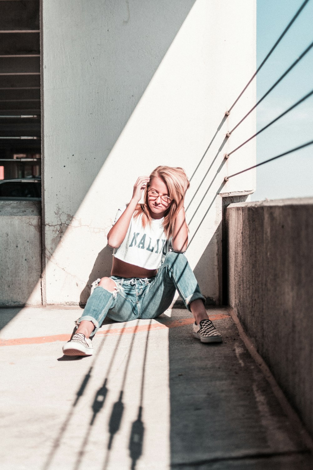 woman sitting on floor wearing white crop top