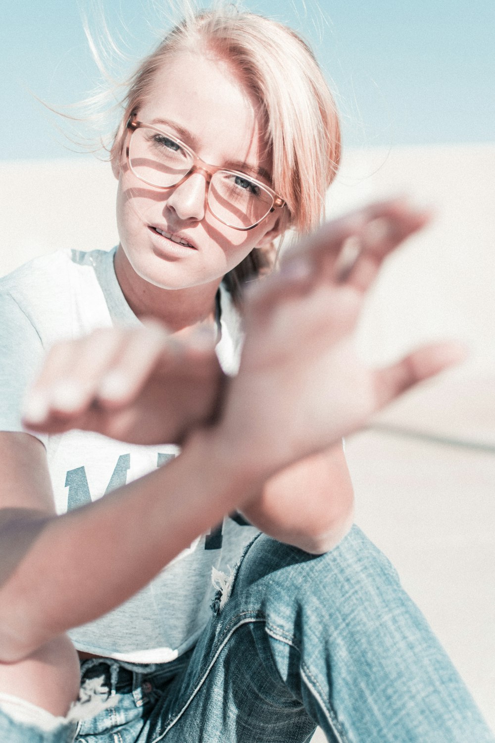 a woman sitting on the ground with her hands in the air