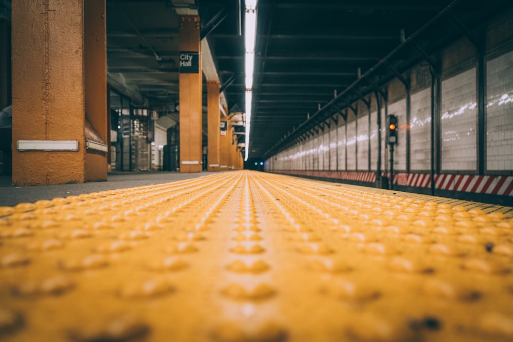 a yellow line on the floor of a subway station