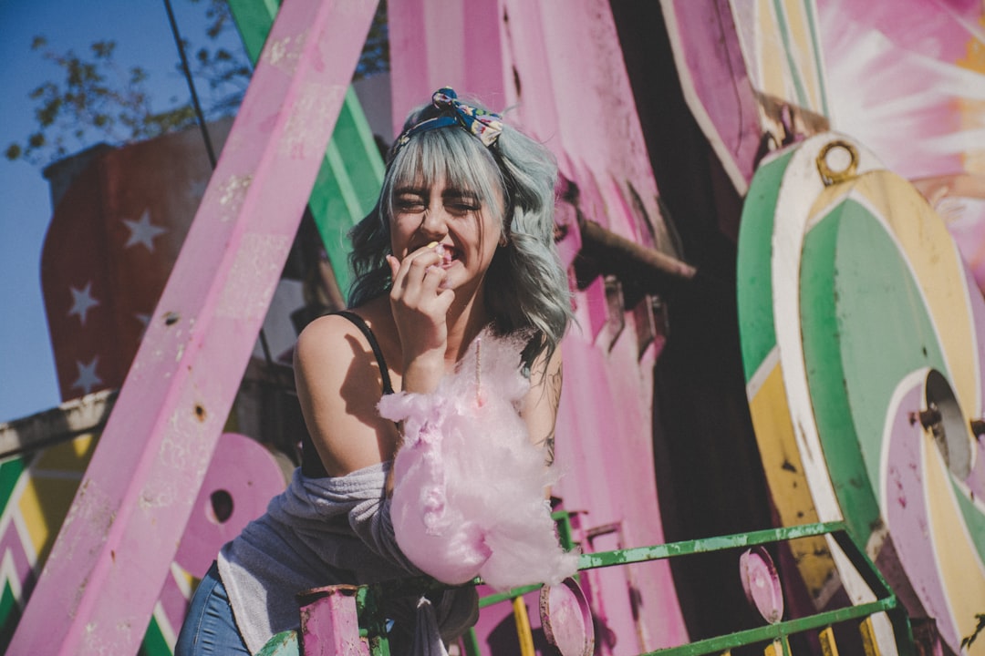 woman eating cotton candy during daytime