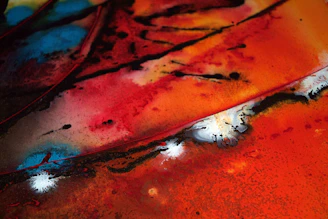 Abstract splatter art on a large canvas with vibrant reds and blues