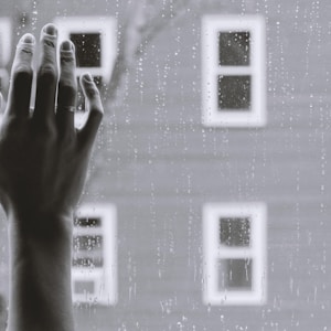 grayscale photo of woman right hand on glass