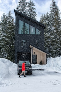 A snow-covered luxury home with cleared pathways and driveway, highlighting premium snow plowing service.