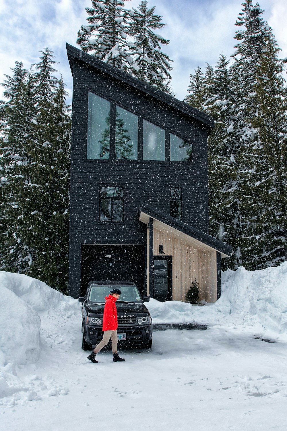 man walking in front of black car