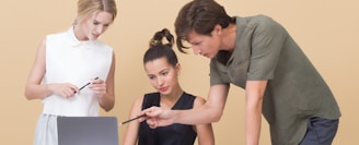 man teaching woman while pointing on gray laptop