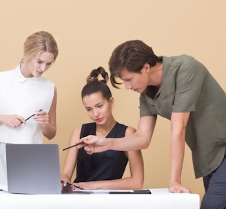 man teaching woman while pointing on gray laptop