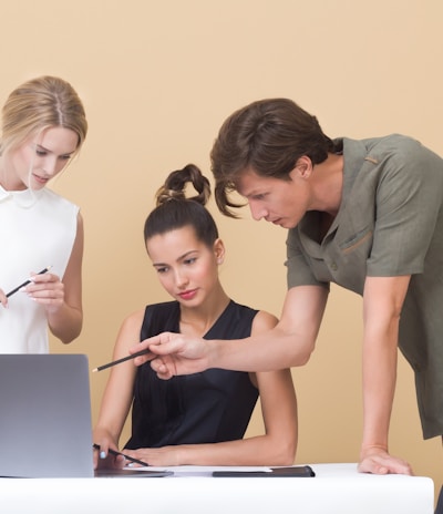 man teaching woman while pointing on gray laptop