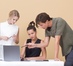 man teaching woman while pointing on gray laptop