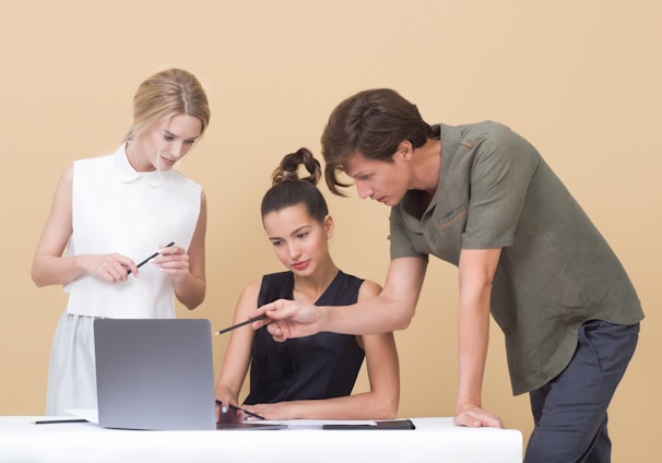 man teaching woman while pointing on gray laptop