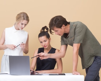 man teaching woman while pointing on gray laptop