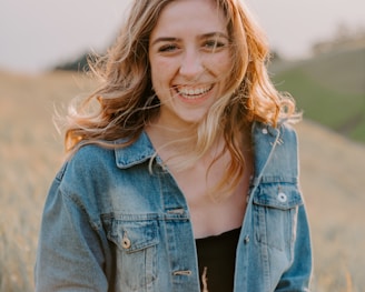 smiling woman sitting on grass during daytime