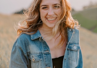 smiling woman sitting on grass during daytime