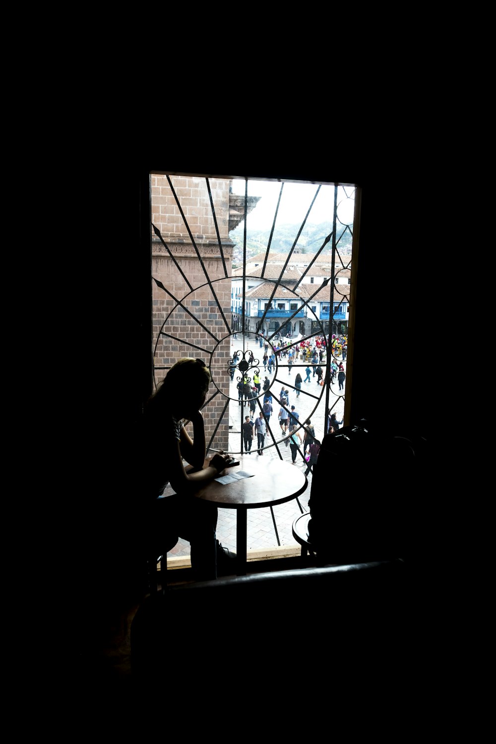 silhouette photo of woman sitting at table