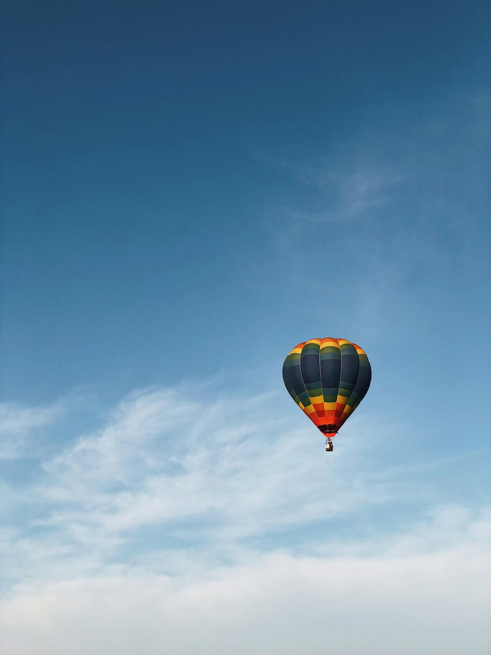 mehrfarbiger Heißluftballon am bewölkten Himmel