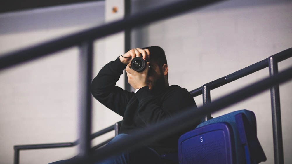 man sitting and taking photo at daytime