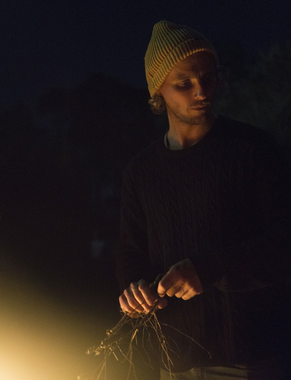 man holding grass at nighttime