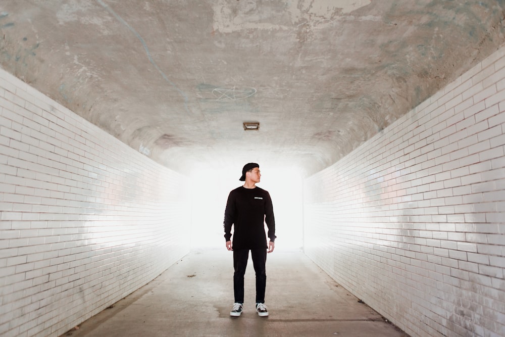 man standing in building with white walls looking on his left side