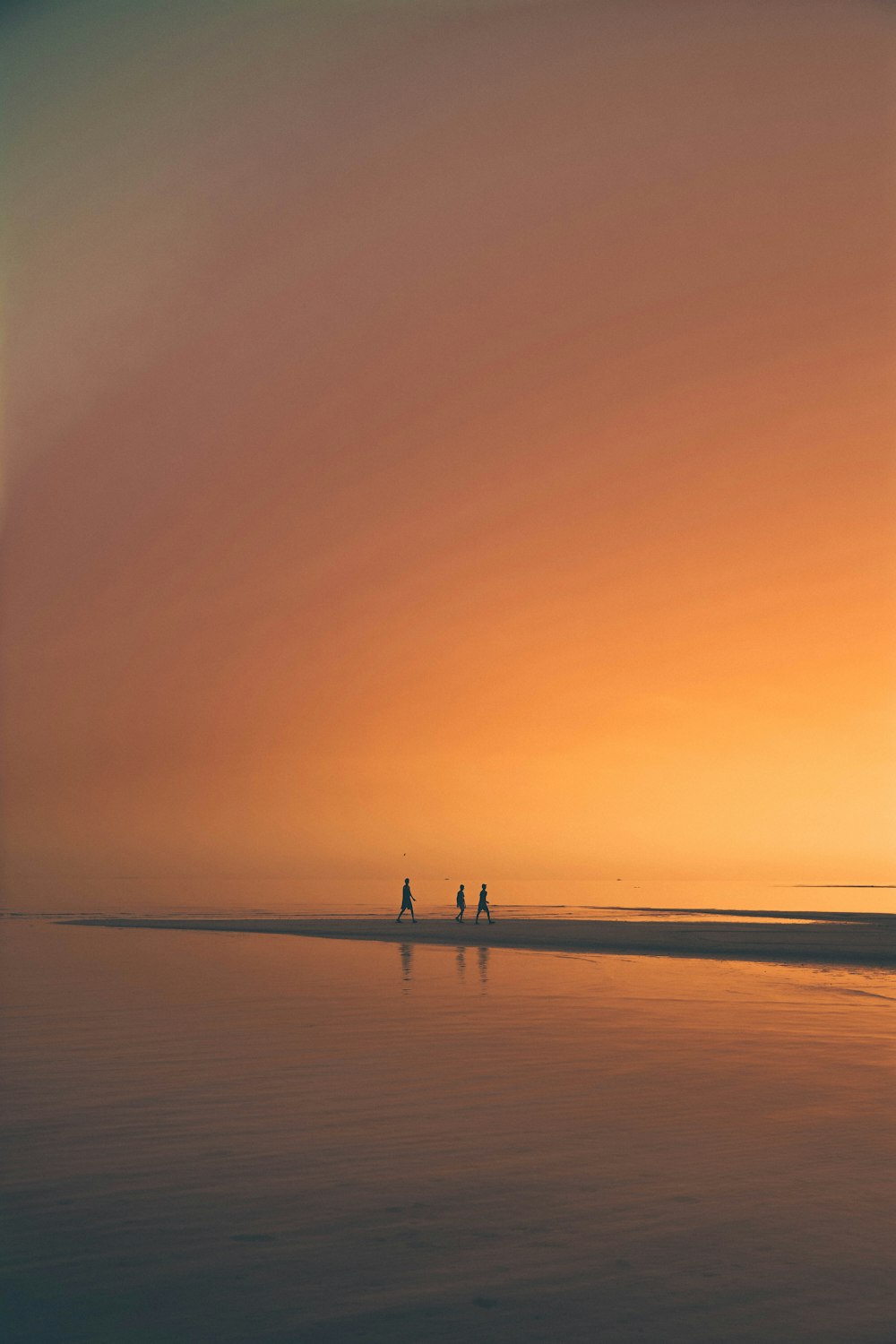 silhoutte de três pessoas na praia