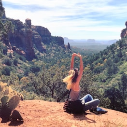 A smiling client stretching outdoors with a scenic canyon backdrop.