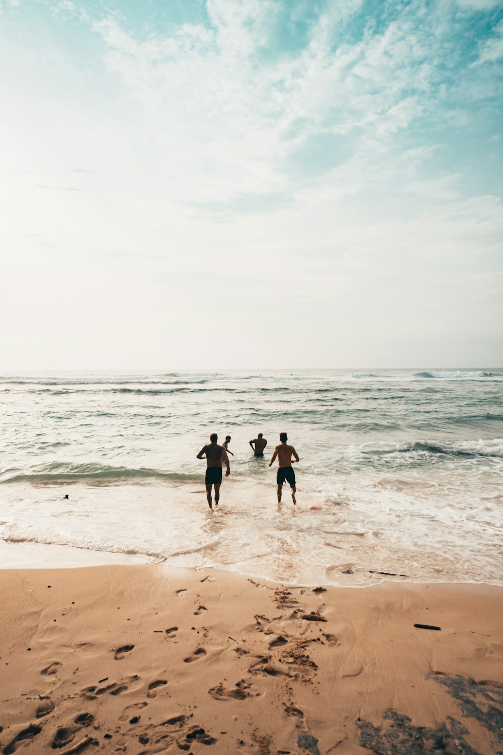 men running toward beach