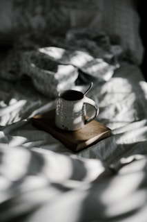 white enamel cup on brown book