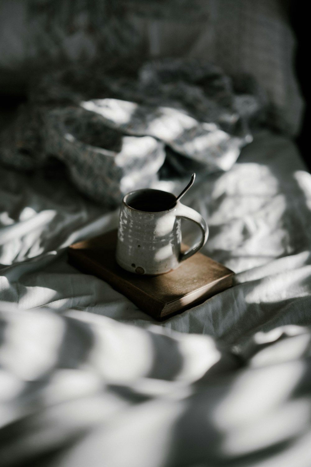 white enamel cup on brown book