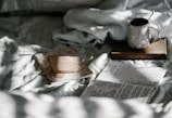 white mug beside white paper