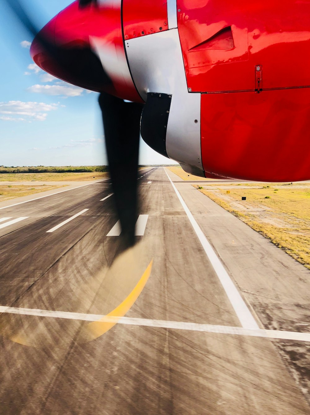 close-up photography white and red plane above runway