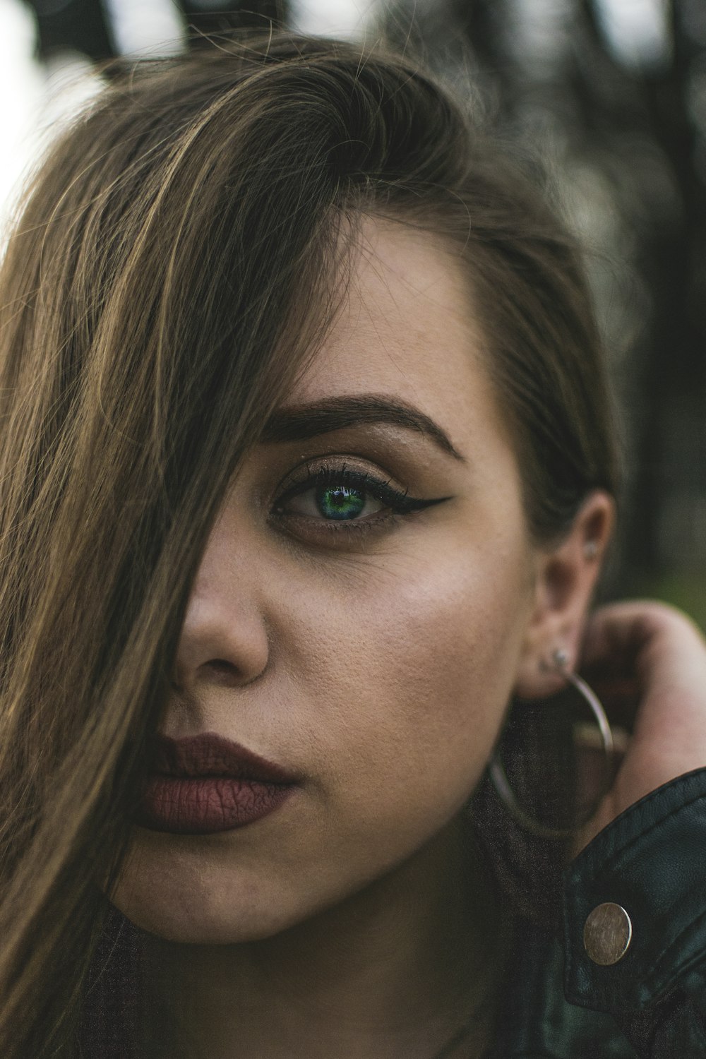 woman holding hair at the back of her ear taking selfie