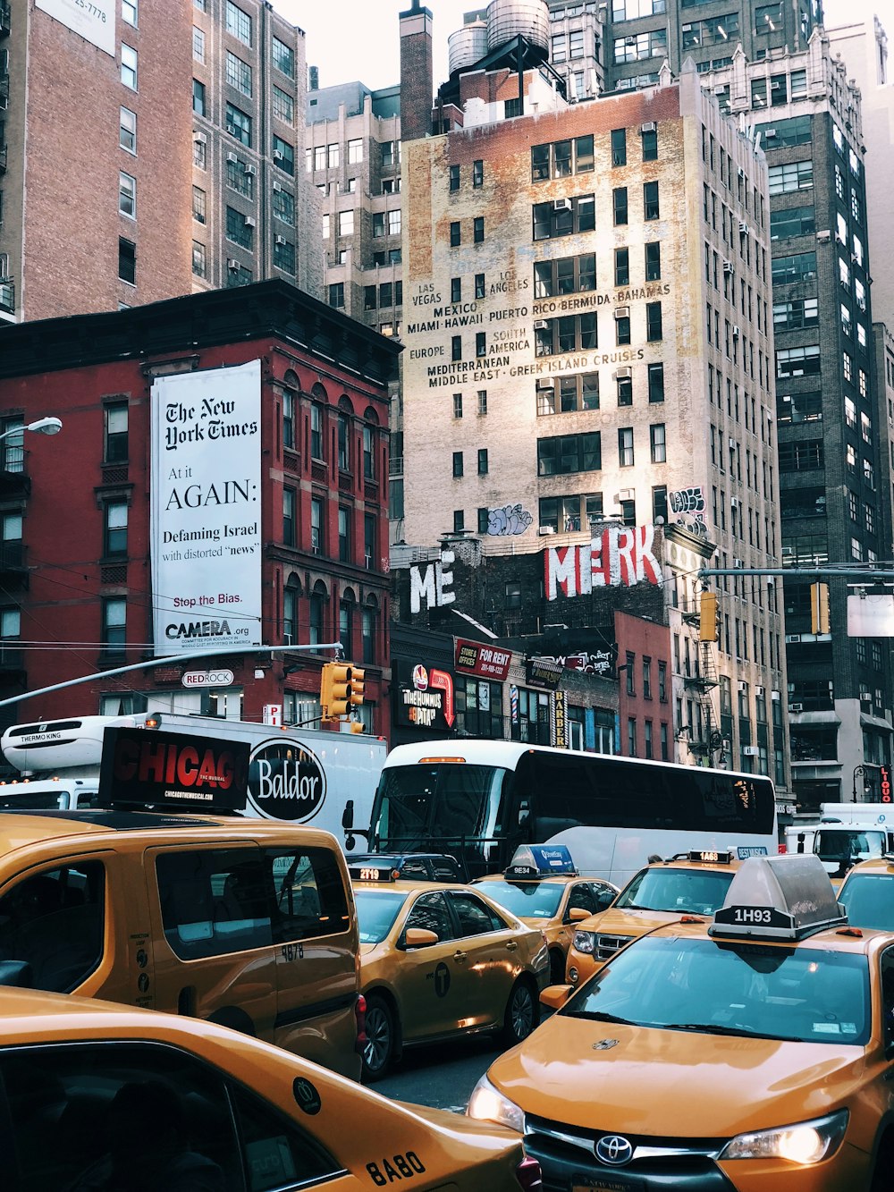 yellow taxi cab on road near buildings