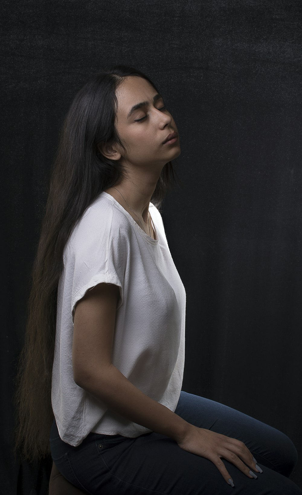 woman in white shirt sitting on chair