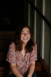 woman sitting on wooden stair smiling