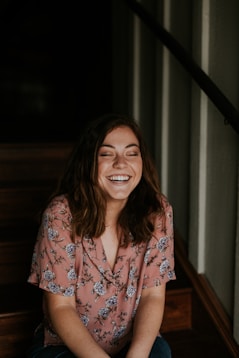 woman sitting on wooden stair smiling