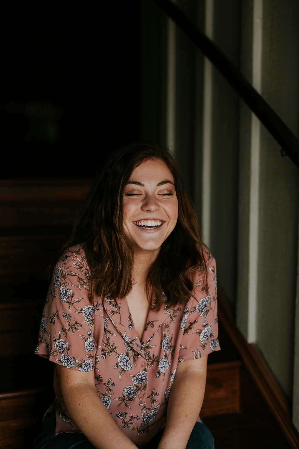 woman sitting on wooden stair smiling
