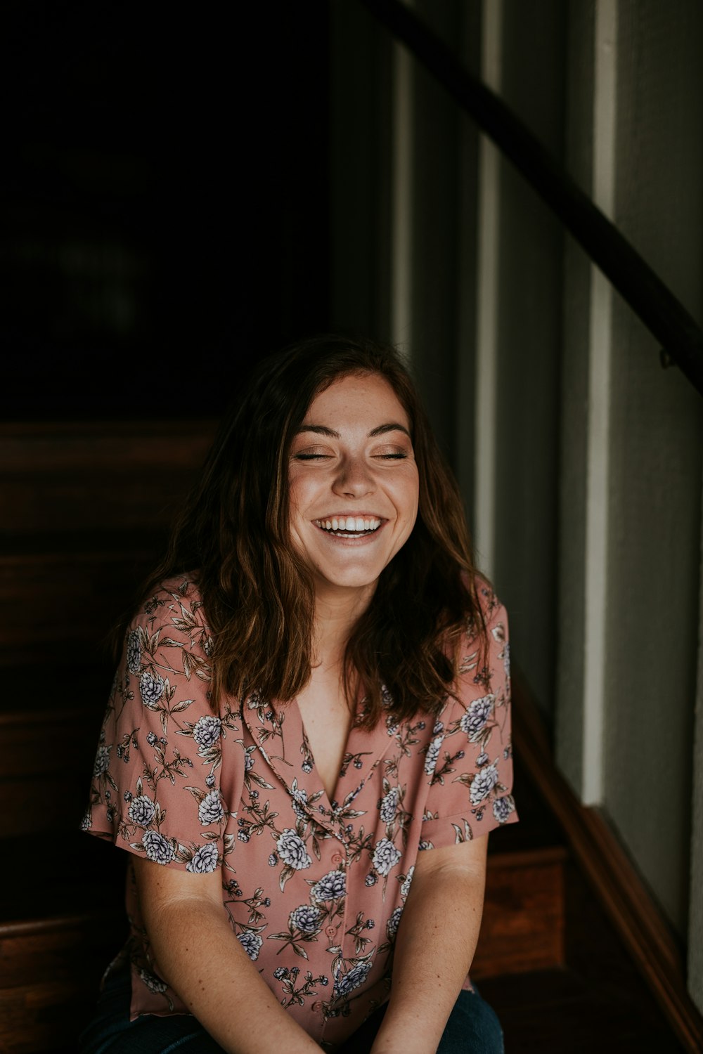 mulher sentada na escada de madeira sorrindo