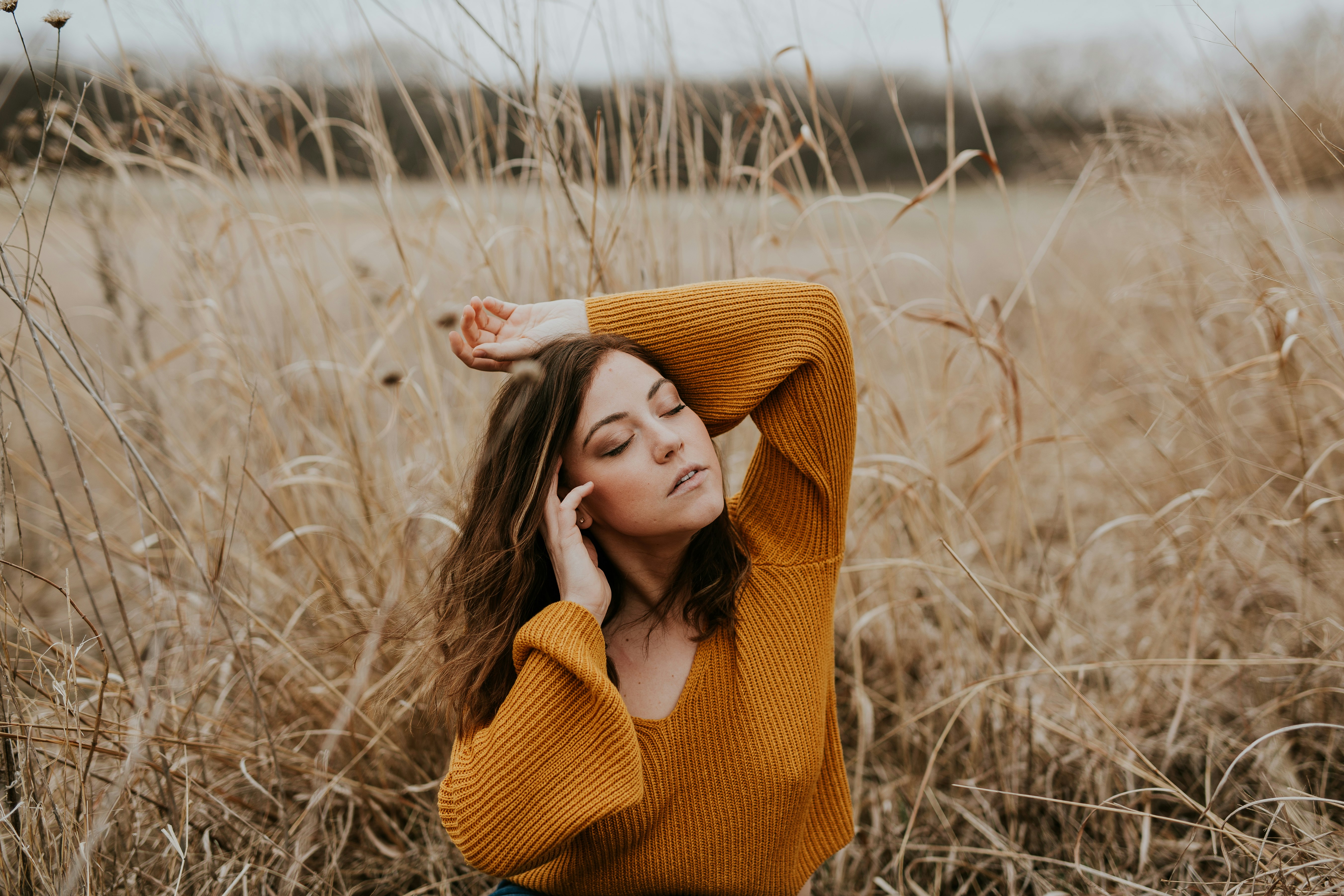 woman raisin hand up on brown field